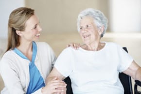 A nurse smiling at an elderly 